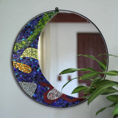 a mirror that is sitting on a wall next to a potted plant in front of it