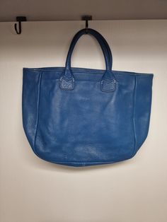 D67 There are minor stains.Please look carefully at the photos, as they are considered to be part of the description. This Ann Taylor tote bag is a stylish accessory for any casual or workwear outfit. The bag features a pebbled texture pattern and is made of high-quality leather in a beautiful sapphire blue color. The bag has an open closure and a large size, measuring 17 inches in width and 12 inches in height.  The bag's handles are made of matching leather in a blue color, adding a pop of contrast to the white contrast stitching throughout the bag. The tote bag has a modern and high-fashion style, with accents that make it stand out from the rest. This bag is perfect for anyone looking for a large, versatile bag that can be used for any occasion. Casual Textured Leather Satchel With Double Handle, Casual Textured Leather Double Handle Satchel, Casual Textured Leather Shoulder Bag For Errands, Casual Textured Leather Shoulder Bag For Daily Use, Travel Tote Bag With Pebbled Texture, Pebbled Texture Tote Bag For Travel, Chic Bags With Pebbled Texture For Daily Use, Leather Bag With Pebbled Texture For Shopping, Rectangular Shoulder Bag With Pebbled Texture For Travel