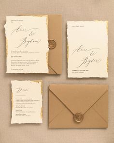 the wedding stationery is set up with an envelope, wax stamp and gold foil