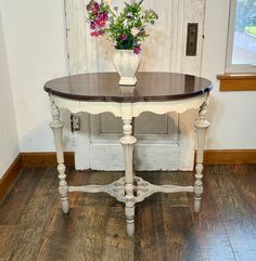 a vase with flowers sitting on top of a table in front of a white door