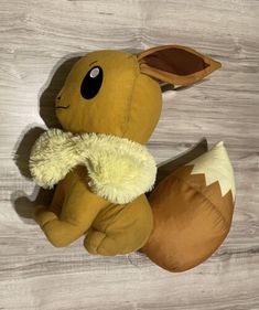 a stuffed animal that looks like a pokemon pikachu sitting on top of a wooden floor