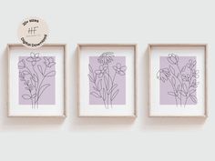 three framed flowers are hanging on the wall next to each other, and one is purple