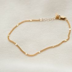 "The anklet that shines like summer incarnate. Each chain is dotted with little sunbursts to catch the light--like fireflies, twinkling lights and golden hour all rolled into one! Style it solo, stack with other anklets or add your favorite charm for an extra sparkle of personalization. Every piece is handcrafted and hand-personalized with love in La Conner, WA, using 90% recycled and 100% ethically sourced raw materials from the USA--because it's better that way. Includes free gift-ready packaging (featuring a care card and traditional letterpress goodies made by my dad)!  MATERIALS: * Gold = 14k gold filled * Silver = sterling silver AT CHECKOUT: * If you chose \"other\" for length, specify which length you'd like in a note. * Select expedited shipping (and add a note with your ideal del Elegant Summer Bracelets With Tiny Beads, Delicate Gold Bracelets For Summer, Adjustable Delicate Chain Anklet For Everyday, Gold Anklets For Everyday Summer Wear, Everyday Gold Chain Anklets, Gold Chain Bracelet As Summer Gift, Gold Bracelet With Delicate Chain For Summer, Minimalist Gold Anklets For Everyday, Gold Delicate Chain Bracelet For Summer