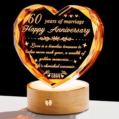 a heart shaped glass award with an inscription on it that reads, 60 years of marriage happy anniversary