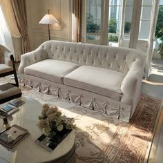 a living room filled with white furniture and lots of window sills on top of them