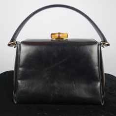 Vintage Gucci Black Leather Bamboo Turnlock Top Handle Bag With Crossbody Strap Made In Italy. * Tracking Number Included * Sourced From The Reuse Sector. Size - Small Suggestions - Collector's Item - Casual & Formal Item Condition Please Understand That Since These Items Are Vintage And/Or Recycled, They May In Fact Show A Little Sign Of Wear, Aging, Or Slight Discoloration. If We List Something As New Old Stock (Nos) Or New, It Will Be In Excellent Condition. Any Other Characterization Is Subj Gucci Black Shoulder Bag With Bamboo Handle, Gucci Black Bag With Bamboo Handle, Black Gucci Bag With Bamboo Handle, Classic Evening Shoulder Bag With Bamboo Handle, Elegant Black Shoulder Bag With Bamboo Handle, Evening Bag With Bamboo Handle And Top Handle Shape, Evening Bag With Bamboo Top Handle, Evening Bags With Top Handle And Bamboo Detail, Formal Black Shoulder Bag With Bamboo Handle