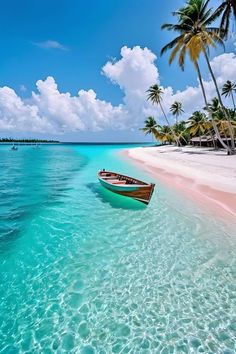 a boat is sitting in the clear blue water near some palm trees and white sand