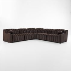 a brown sectional sofa with pillows on the top and bottom part, in front of a white background