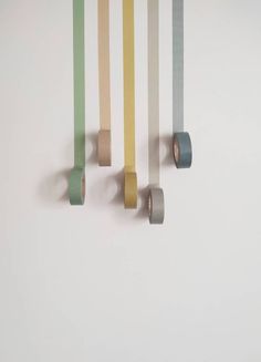 three rolls of tape are hanging on the wall next to each other in different colors