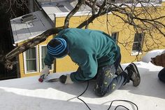 two men are working on the roof of a house with tools and wires attached to them