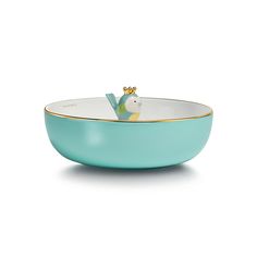 a blue bowl with a bird on top and two gold trimmings in the bottom