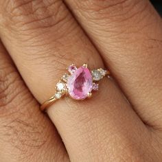 a woman's hand with a pink and white diamond ring