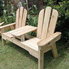 two wooden lawn chairs sitting in the grass