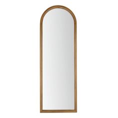 an arched mirror on a white wall with a wooden frame and wood trimmings