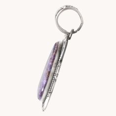 This Charoite Statement Pendant features a one-of-a-kind purple charoite stone, carefully handcrafted with unique silverwork. Made with stunning sterling silver, this pendant is the perfect addition to any jewelry collection. The elegant design adds a touch of sophistication to any outfit, making it a must-have for any fashion-forward individual. Sterling Silver Pendant Charoite Stone 3 1/4" Length (including bail), 1 1/2" Width Artist: R. Tom (hallmarked) Outfit Making, Statement Pendant, Local Artisans, Sterling Silver Pendant, Sterling Silver Pendants, Elegant Design, Unique Pieces, Silver Pendant, Fashion Forward