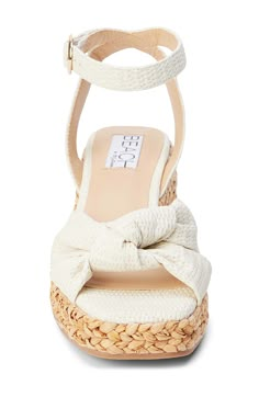 A knotted vamp accent brings modern dimension to a boho-cool sandal lifted by a raffia-wrapped platform and integrated wedge heel. 3" heel; 1" platform Adjustable ankle strap with buckle closure Cushioned footbed with arch support Synthetic upper, lining and sole Imported Sorority Recruitment Shoes, Pretty White Shoes, Beach High Heels, Costal Grandma Shoes, Blanco By Nature, Nude Wedge Sandals, Platform Heels For Beach Season, Sorority Rush Shoes, Summer Beach Block Heels With Platform