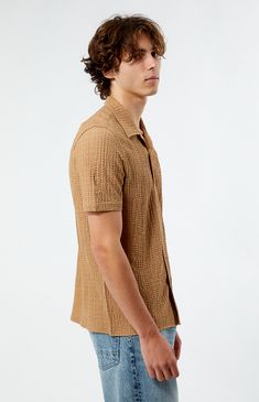 PacSun introduces the Pointelle Textured Woven Camp Shirt, showcasing a collared neckline and button-up front for a classic look. Crafted from crinkled fabrication, this shirt features short sleeves, offering both comfort and style in one piece.


	Collared neckline
	Short sleeves
	Button closures
	Standard fit
	Crinkle fabric
	97% polyester, 3% spandex
	Machine washable
	Model is wearing size medium
	Model Measurements: 6’1”  Height, 30” Waist, 35” Hips Collared Beige Camp Shirt With Button Closure, Beige Collared Camp Shirt With Button Closure, Beige Johnny Collar Shirt For Summer, Summer Top With Collar And Placket, Collared Shirt With Placket For Summer, Casual Fitted Camp Shirt With Spread Collar, Summer Collared Camp Shirt For Workwear, Summer Collared Shirt With Placket, Summer Workwear Camp Shirt With Collar