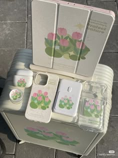 an assortment of cell phones sitting on top of a table next to each other with flowers painted on them