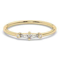 a yellow gold ring with three stones on the side and two diamonds in the middle