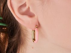 A fun take on the classic hoop. These hoops pair pink enamel and brilliant gold into one must-have design. Wear solo or style with refined studs for a sleek finish. 14k gold plated over brass. Hoop dimension: 18mm x 24mm Hypoallergenic, nickel and lead free Tarnish resistant Pink Enamel, Ear Cuff, Gold Plate, Sleek, Plating, Brass, Pink, Gold, Design