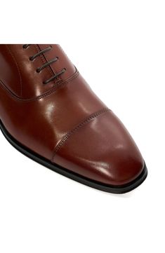 Tonal stitching subtly highlights the cap toe of a classic oxford fashioned from smooth, burnished leather. Lace-up style Leather upper/textile lining/synthetic sole Imported Fitted Oxfords With Leather Sole, Timeless Fitted Plain Toe Oxfords, Timeless Dress Shoes For Derby, Classic Cap Toe Oxfords For Derby, Fitted Plain Toe Oxford With Leather Sole, Classic Fitted Oxfords For Derby Events, Classic Fitted Oxfords For Derby, Fitted Oxford Derby Shoes With Almond Toe, Fitted Round Toe Oxfords For Derby