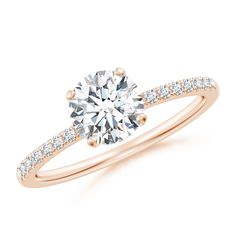 a rose gold engagement ring with diamonds on the band and a round cut diamond in the center