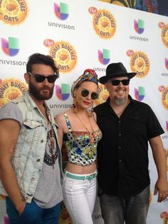 three people standing next to each other in front of a wall with the words univision on it