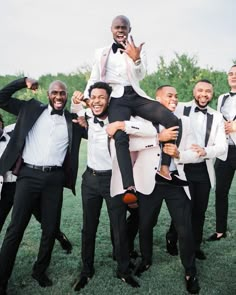 a group of men in tuxedos are posing for a photo with each other