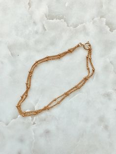 This is a beautiful double strand bracelet. It is made of 14/20 gold-fill and had small round gold beads attached to the chain all the way around. This bracelet has two chains attached to the same clasp, so it is an all in one layering bracelet. Length: 6.75 inches. If you need a different size please leave me a note at checkout. Matching Necklace: https://www.etsy.com/listing/239145000/double-strand-gold-beaded-chain-necklace?ref=shop_home_active_16 Gold Bracelets With Delicate Chain And Round Beads, Gold Minimalist Chain Bracelet With Gold Beads, Minimalist Gold Chain Bracelet With Gold Beads, Gold Double Strand Chain Bracelet As Gift, Gold Bracelet With Beaded Chain And Round Beads, Gold Double Strand Bracelet With Delicate Chain, Gold Double Strand Chain Bracelet For Gift, Gold Bracelets With Chain And Round Beads, Gold Bracelet With Chain And Round Beads