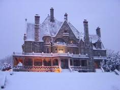 a large house covered in snow with lots of windows and lights on the front porch