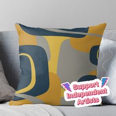 a pillow with the words support independent artists on it and an image of abstract shapes