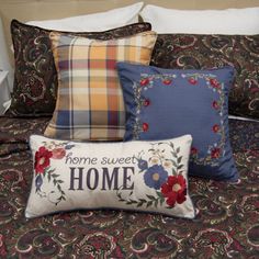 a bed topped with lots of pillows next to a night stand