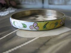 "A vintage Chinese yellow and white cloisonne bangle bracelet depicting beautiful flowers and foliage. It measures 3/8'' wide and 2 5/8'' across from side to side. Measures 8'' along the inside, so it will fit over any average hand. Stamped \"MADE IN REP. CHINA\" on the inside of the bangle. In very good condition." Vintage Bracelet Jewelry For Spring, Handmade Vintage Bracelets For Spring, Vintage Flower Bracelets For Spring, Vintage Spring Bracelet Jewelry, Vintage Spring Jewelry Bracelet, Vintage White Bangle For Wedding, Vintage White Wedding Bangle, Vintage White Flower Bracelets, Asian Jewelry