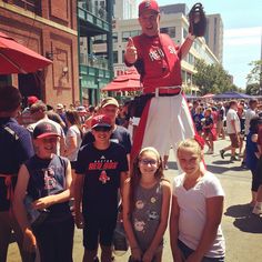 a group of young people standing next to each other in front of a giant statue