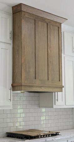 a stove top oven sitting inside of a kitchen next to white cabinets and counter tops