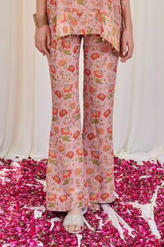 Pink top with floral print and metal coin, ghungroo bead drops on hem. Paired with pant. - Aza Fashions Bollywood Style Festive Spring Pants, Spring Bollywood Festive Pants, Festive Bollywood Spring Pants, Traditional Floral Print Festive Bottoms, Traditional Floral Print Festive Pants, Festive Floral Print Pants, Festive Pants With Printed Motifs, Festive Spring Palazzo Set, Summer Festive Floral Print Pants