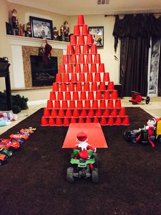 a christmas tree made out of orange cones and toys on the ground in front of it