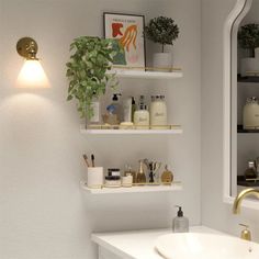 a white bathroom with shelves filled with personal care items and plants on the shelf next to the sink