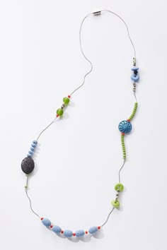 a necklace made with beads and stones on a white background, the bead is attached to a cord