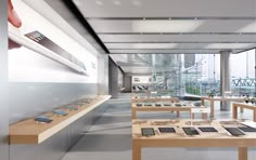 the interior of an apple store with lots of ipads on tables and in front of large windows