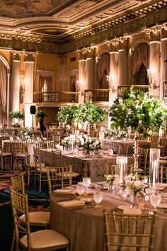 the tables are set up for a formal function in an ornate setting with chandeliers and floral centerpieces