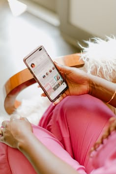 a woman laying on the floor with her cell phone in her hand and looking at it