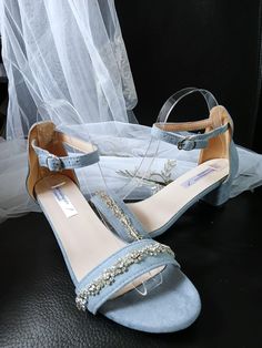 Complete your bridal ensemble with these light blue suede sandals adorned with sparkling crystals. These embellished wedding shoes are perfect for the bride or bridesmaid looking for a touch of glamour. Featuring a peep-toe design and a low heel, these shoes offer both style and comfort for your special day. Step down the aisle in style with these elegant and eye-catching footwear. Specifications: 1.Heel Height: 5cm 2.Closure Type: buckle strap 3.Colour: light blue Fit: 1) If your feet are narro Embellished Wedding Shoes, Wedding Shoes For Bride, Shoes For Bride, Womens Wedding Shoes, Blue Fits, Bride Shoes, Suede Sandals, Toe Designs, Blue Suede