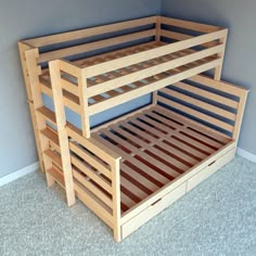 a wooden bunk bed sitting on top of a carpeted floor next to a wall