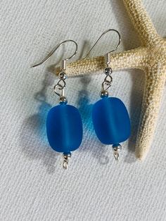 Blue Cultured sea glass silver plated wire earrings with silver plated beads. The silver plated earring hooks and wire are tarnish resistant. The earring hooks are nickel free. These are a great gift for someone special! Made in Hawaii. Blue Sea Glass Nickel Free Earrings, Blue Sea Glass Nickel-free Earrings, Beach Earrings In Silver With Recycled Glass, Nickel-free Blue Sea Glass Earrings, Beach Silver Earrings With Recycled Glass, Silver Recycled Glass Earrings For The Beach, Silver Recycled Glass Beach Earrings, Handmade Blue Sea Glass Earrings, Blue Recycled Glass Nickel-free Earrings