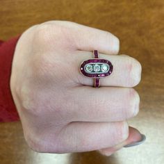 This stunning Ruby ring is set in 14k yellow gold and features three old mine cut diamonds with a total approximate weight of 0.51 carats. The diamonds are J color, and VS2-SI1 clarity. Surrounding the center stones is a row of natural calibre French-cut rubies. This ring is antique, made in Russia, with old Russian gold marks and maker marks. ✦ DIAMOND SPECIFICATIONS: Diamond Cut: Old Mine Cut ✦ ENGAGEMENT RING SPECIFICATIONS: Ring Material: Gold, Platinum Ring Era: Edwardian Era Stones: Diamon Antique Platinum Three Stone Diamond Ring, Antique Three Stone Round Diamond Ring, Antique Three Stone Platinum Rings, Antique Platinum Three Stone Rings, Heirloom Three Stone Platinum Ring, Oval Ruby Ring With Three Diamonds, Oval Three Stone Ruby Ring With Diamonds, Heirloom Platinum Three Stone Ring, Heirloom Three-stone Platinum Ring