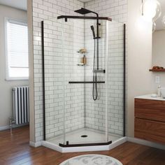 a bathroom with a wooden floor and white tiled walls, including a walk in shower