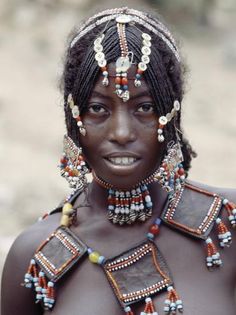 an african woman wearing beaded headdress and necklaces