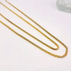 For those who love a touch of sophistication mixed with a bit of edge, our box chain is the perfect style statement. Whether you're layering or wearing it solo, these pieces add a glamorous touch to any outfit. Versatile and timeless, they exude elegance with an edge. (Just like you!) Gift Snake Chain Necklace With Delicate Chain, Yellow Gold Box Chain Necklace For Layering, Layering Link Necklace With Box Chain, Long Box Chain Necklace As Gift, Gift Box Chain Long Necklace, Gift Long Box Chain Necklace, Gold Double Strand Box Chain Necklace, Double Strand Box Chain Necklace For Gift, Double Strand Box Chain Necklace For Gift Giving