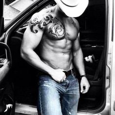 a shirtless man with a cowboy hat standing in the back of a truck door